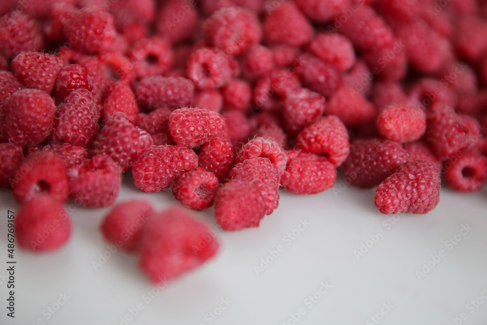 lots of ripe raspberries on a white background, top view lots of ripe raspberries on a white background, top view