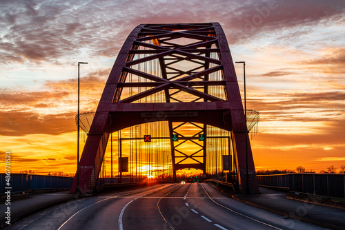 Tableau sur toile Brücke der Solidarität über den Rhein bei Duisburg am Abend bei Sonnenuntergang