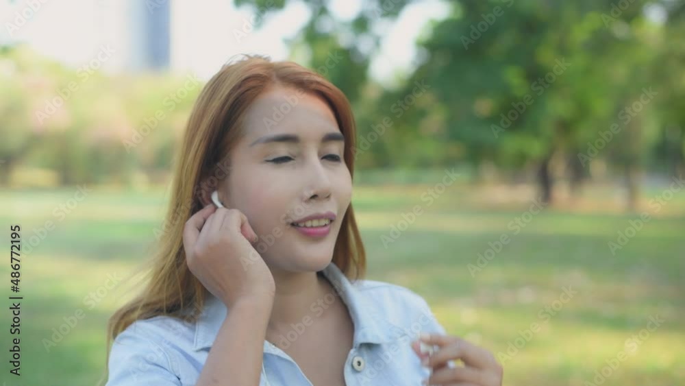 Holiday concept of 4k Resolution. Asian woman wearing headphones in the garden. she is listening to music online. Holiday concept of 4k Resolution. Asian woman wearing headphones in the garden. she is listening to music online.