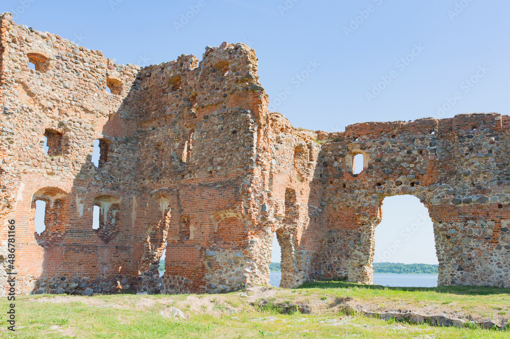 Ruines of the medieval Luzen castle, built by the Livonian knight order, in nowadays Ludza, Latgalia, Latvia. Red brick walls, blue sky, green grass