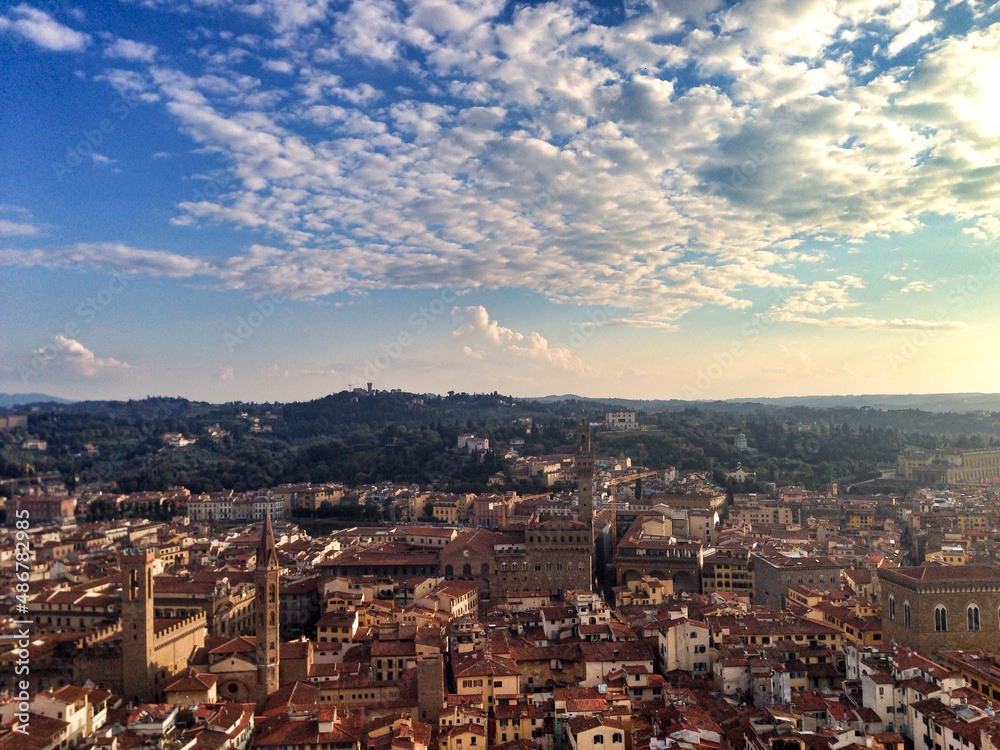 Firenze, Italy. Panoramic view of Florence from the top of Campanile close to Duomo. Tuscany hills on a horizon. Golden hour, cloudy sky.	