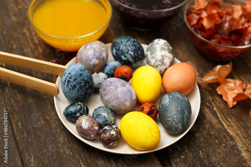 Beautiful Easter eggs with marbled stone effect, colored with natural dye turmeric, onion husk, hibiscus flower tea on dark wooden background