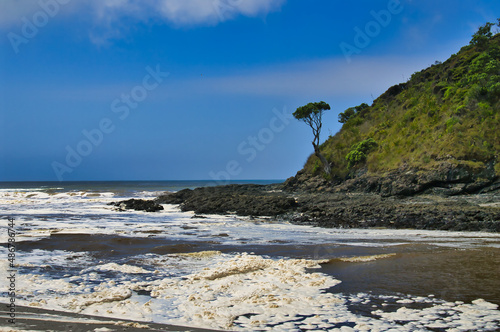 Foamy water and black rocks at the beach of Tapotupotu Bay, in the extreme north of Northland, New Zealand, close to Cape Reinga
 photo