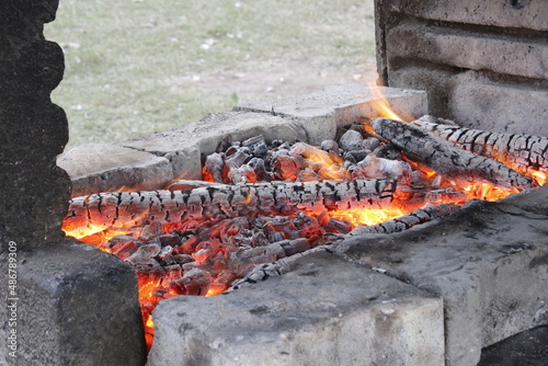 The background shows preparing a fire for barbecue