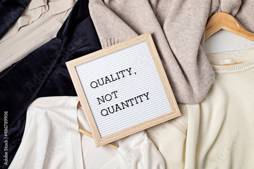 Flat lay of clothes and hangers; assortment of women's clothing. Second hand sustainable shopping; capsule minimal wardrobe; slow fashion idea; quality not quantity concept photo
