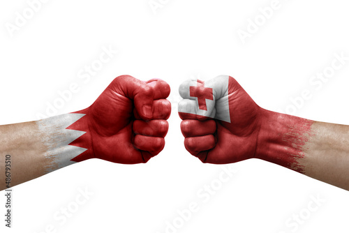 Two hands punch to each others on white background. Country flags painted fists, conflict crisis concept between bahrain and tonga