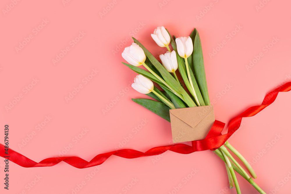 Flowers are white tulips, flatlay. A beautiful bouquet tied with a red ribbon and an envelope isolated on a pastel pink background. object for decoration for women's day, mother's day, anniversary. Flowers are white tulips, flatlay. A beautiful bouquet tied with a red ribbon and an envelope isolated on a pastel pink background. object for decoration for women's day, mother's day, anniversary.