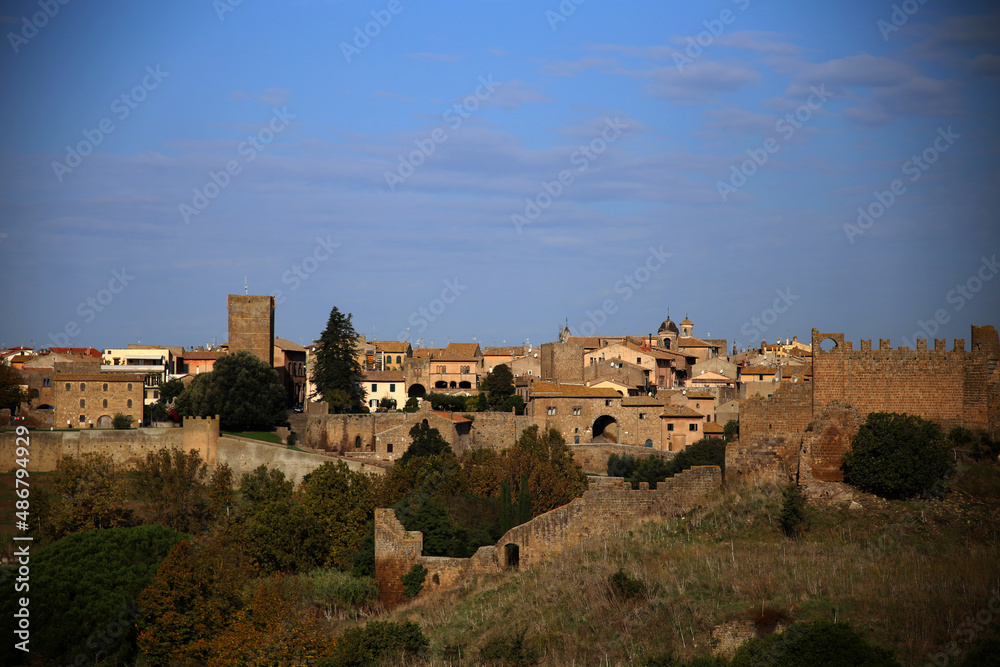 Panorama of the city from the Church of San Pietro, in warm colors at dusk, against the darl blue sky, Tuscania, Tuscia, Lazio, Italy
