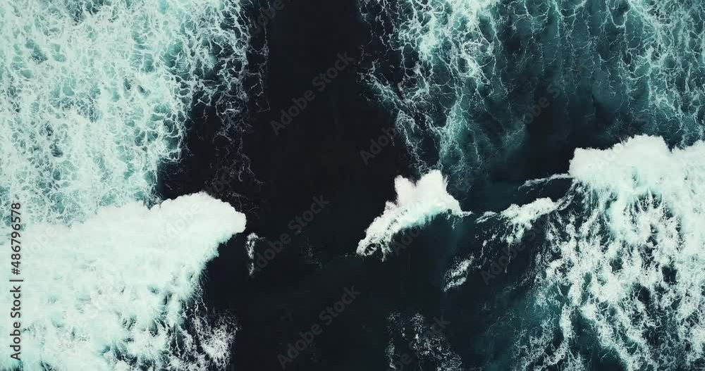 Slow motion from above onto frothy mesmerizing lapping waves of sea on gloomy summer day. Idea of beauty nature and power elements.