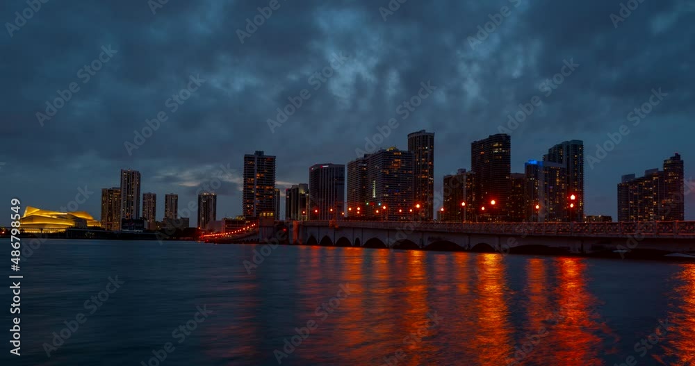 Miami panorama time lapse. Night sky timelapse on Miami beach city. Time lapse of sunset on cityscape sky and clouds moving with water ripple reflection. MacArthur downtown, Causeway city. Miami panorama time lapse. Night sky timelapse on Miami beach city. Time lapse of sunset on cityscape sky and clouds moving with water ripple reflection. MacArthur downtown, Causeway city.