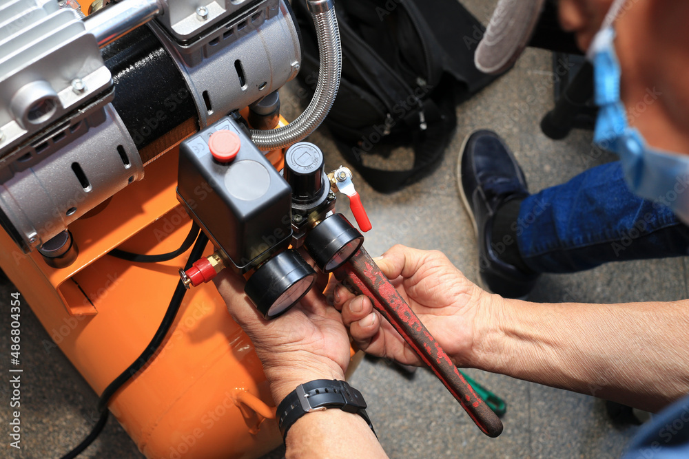 Close-up of a technician fixing a compressor