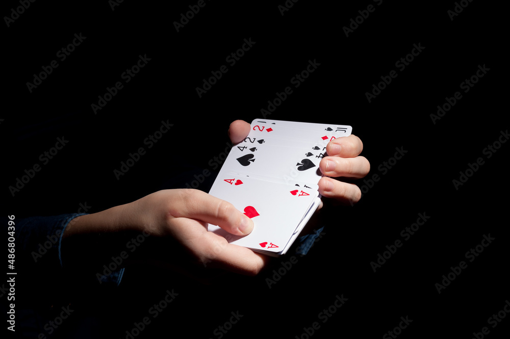 Obraz premium human hands shuffling deck of cards on the dark background