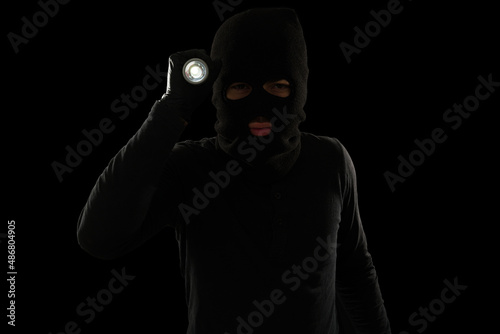 Fototapeta Naklejka Na Ścianę i Meble -  Portrait of a criminal with a flashlight