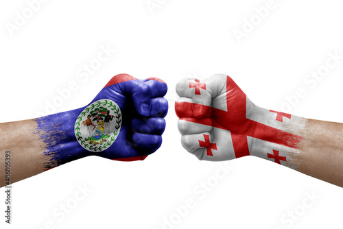 Two hands punch to each others on white background. Country flags painted fists, conflict crisis concept between belize and georgia
