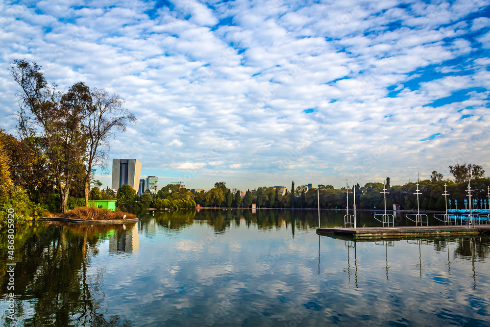 Cityscape with lake in the middle and buildings in the background woods of Chapultepec in Mexico city 