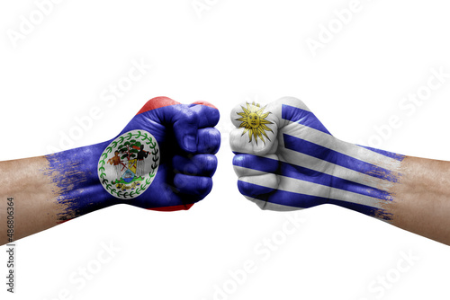 Two hands punch to each others on white background. Country flags painted fists  conflict crisis concept between belize and uruguay