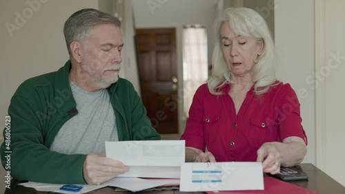 A senior couple on a fixed income feeling the effects of inflation as they go over their budget and some past due bills.