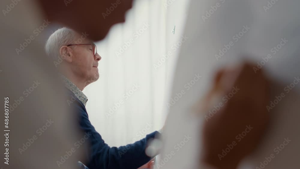 Elder person learning to draw sketch with pencil in art school, attending class lesson for personal development and growth. Artwork drawing on canvas to practice artistic skills. Handheld shot
