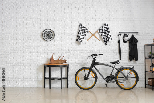 Stylish interior of room with modern bicycle and light brick wall
