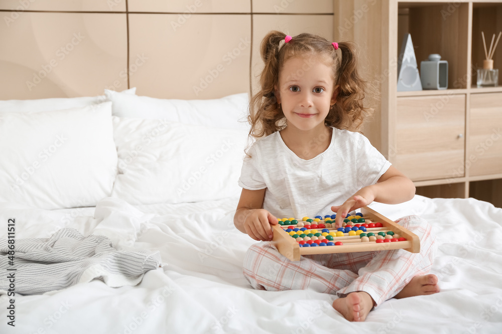 Adorable little girl playing with abacus in bedroom Adorable little girl playing with abacus in bedroom