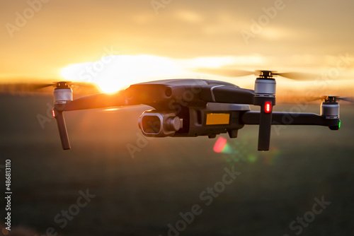 Φωτογραφία Unmanned quadcopter in flight with a digital camera at sunset
