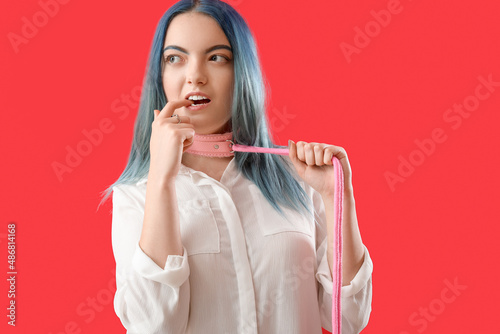 Fotografering Beautiful young woman in collar from sex shop on red background