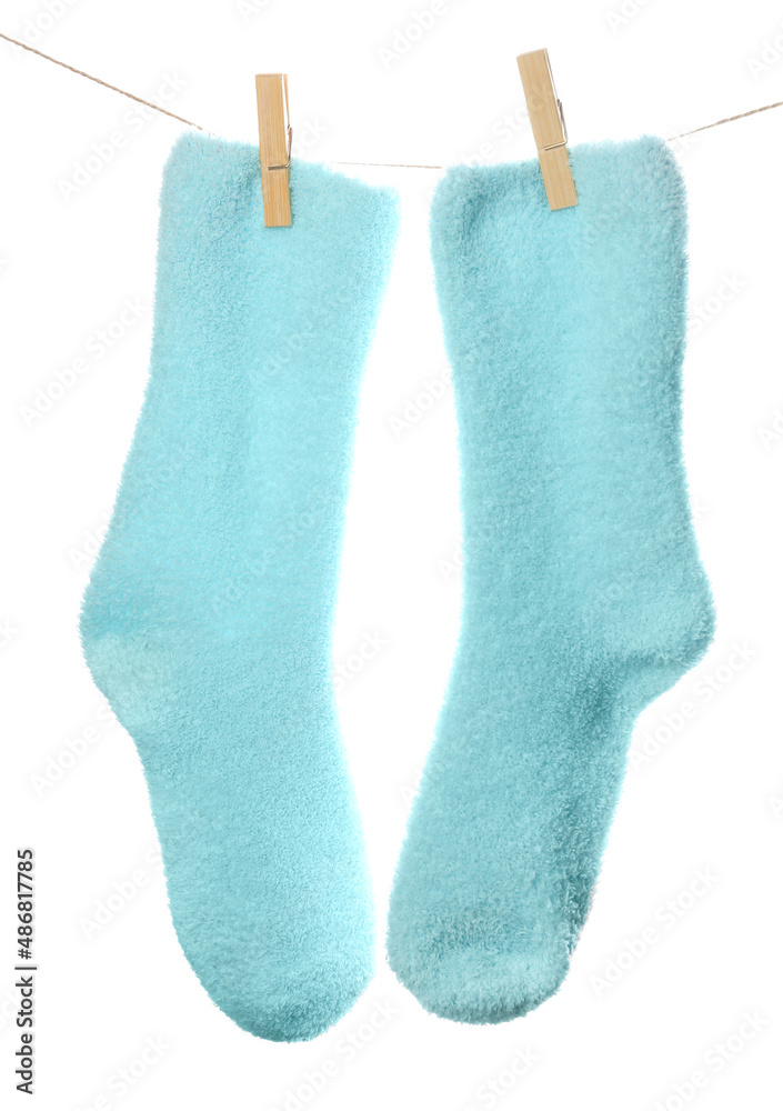 Pair of warm socks hanging on rope against white background, closeup Pair of warm socks hanging on rope against white background, closeup