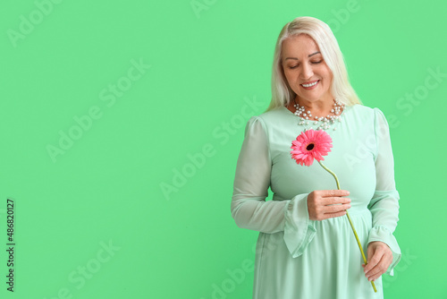 Mature woman holding gerber...