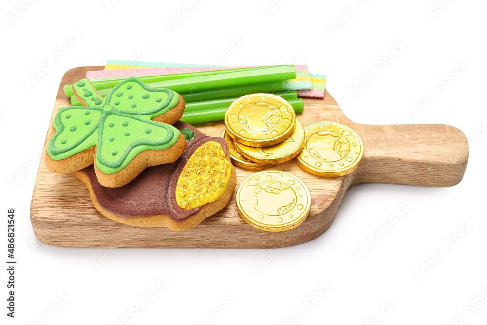 Wooden board with different sweets for St. Patrick's Day celebration on white background