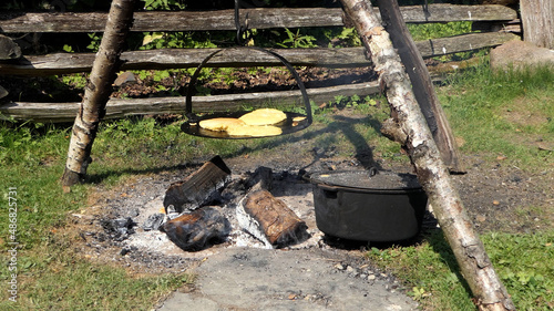 Baking bread on a griddle over a fire outdoors in 1800's America photo