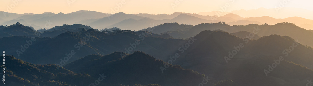 Beautiful dark orange mountain landscape with fog and forest. sunrise and sunset in mountains, Layers of mountain orange rocky hills landscape background.