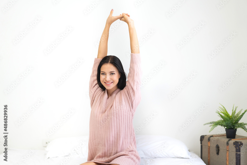 Smiling of cheerful beautiful pretty woman clean fresh healthy white skin posing in warm knitted pink clothes.Girl felling relaxing and enjoy time on the bed at home Smiling of cheerful beautiful pretty woman clean fresh healthy white skin posing in warm knitted pink clothes.Girl felling relaxing and enjoy time on the bed at home
