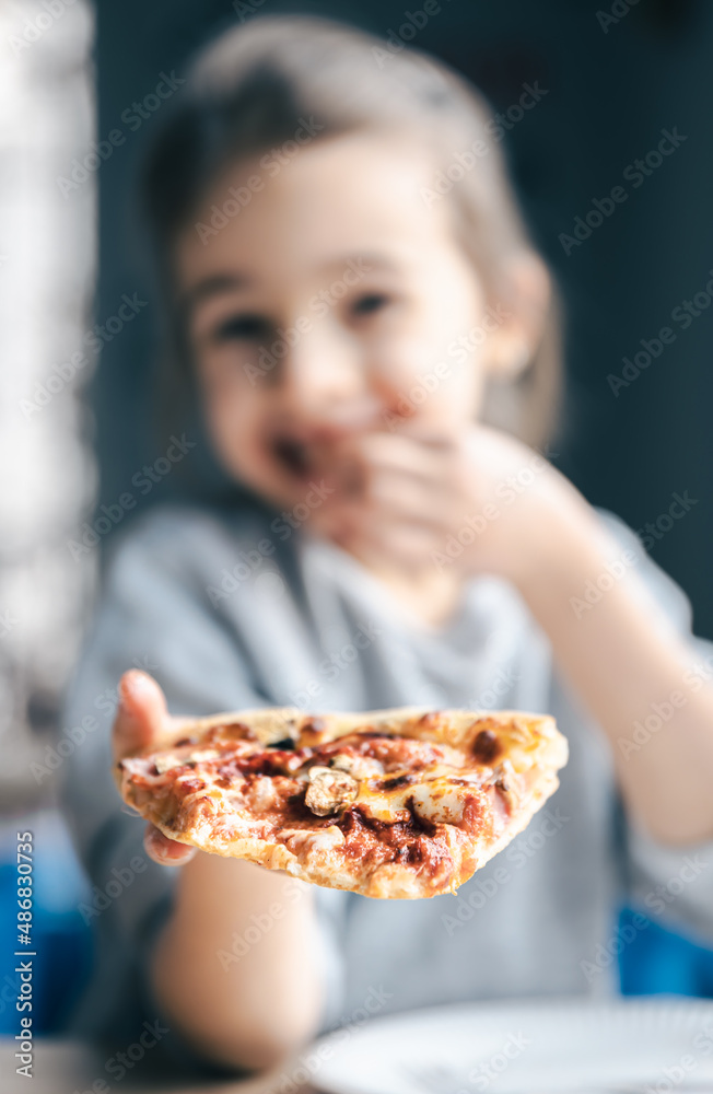 Portrait of a little girl with an appetizing piece of pizza.