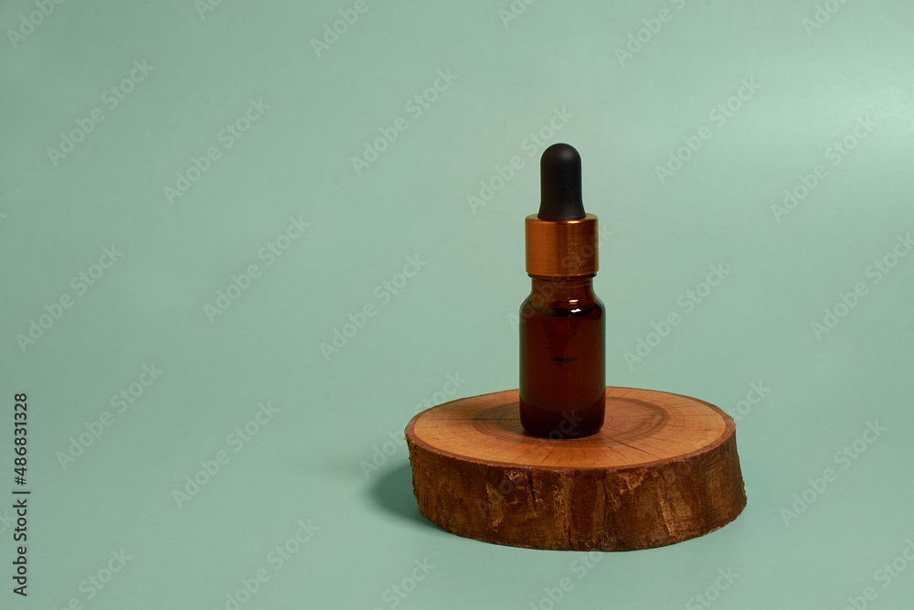 A glass tube with cosmetic oil on a wooden stand A glass tube with cosmetic oil on a wooden stand