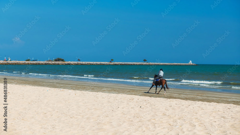 Man riding horse on Cha Am beach at summer