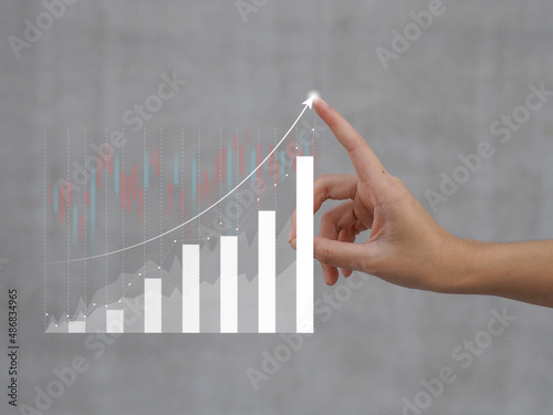 girl's hand showing Growing virtual hologram stocks, growing business in graphs.