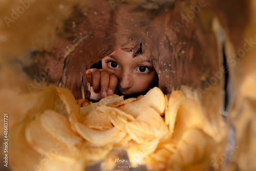 A Girl staring at potato chips inside the chips packet