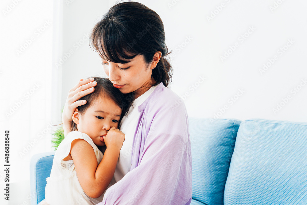 泣く子供の面倒をみるお母さん 泣く子供の面倒をみるお母さん