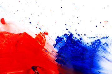 Drops of red and blue paint on a white background.