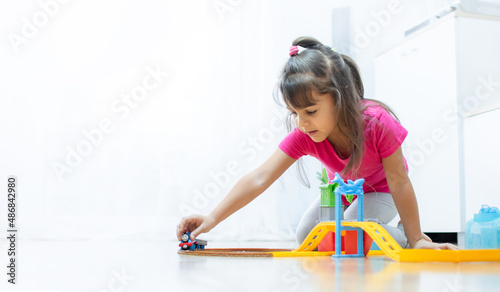 baby game. Little clever caucasian child playing colorful toy railway and train for early development.