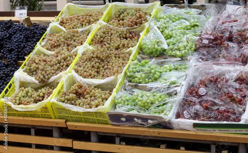 Different grape varieties: green, yellow, red, black on the supermarket shelf in winter.tore.