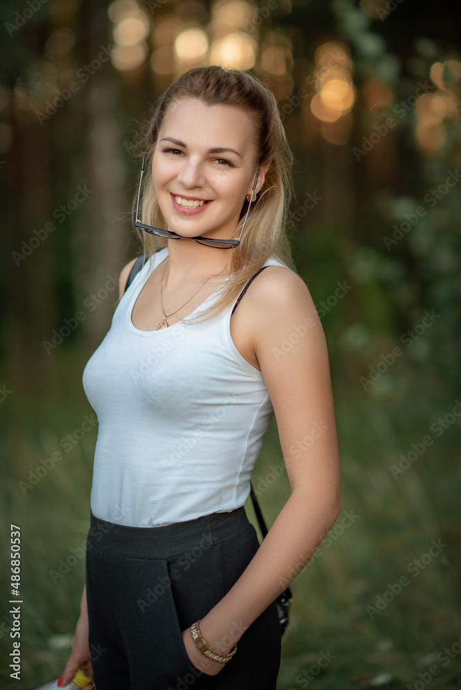 Portrait of a young beautiful fair-haired girl in a white T-shirt.