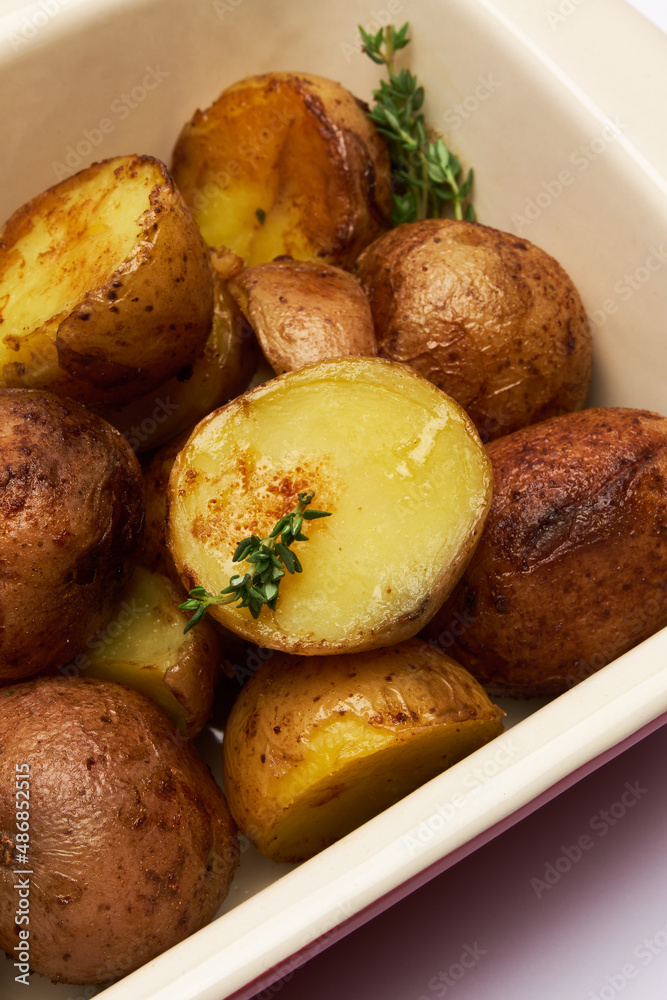 Baked potato in baking dish isolated on white background Baked potato in baking dish isolated on white background