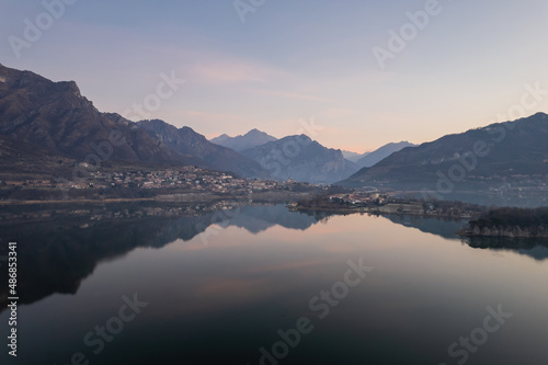 Civate town seen from Lake Annone before the sunrise. Reflection of the mountains in the water.