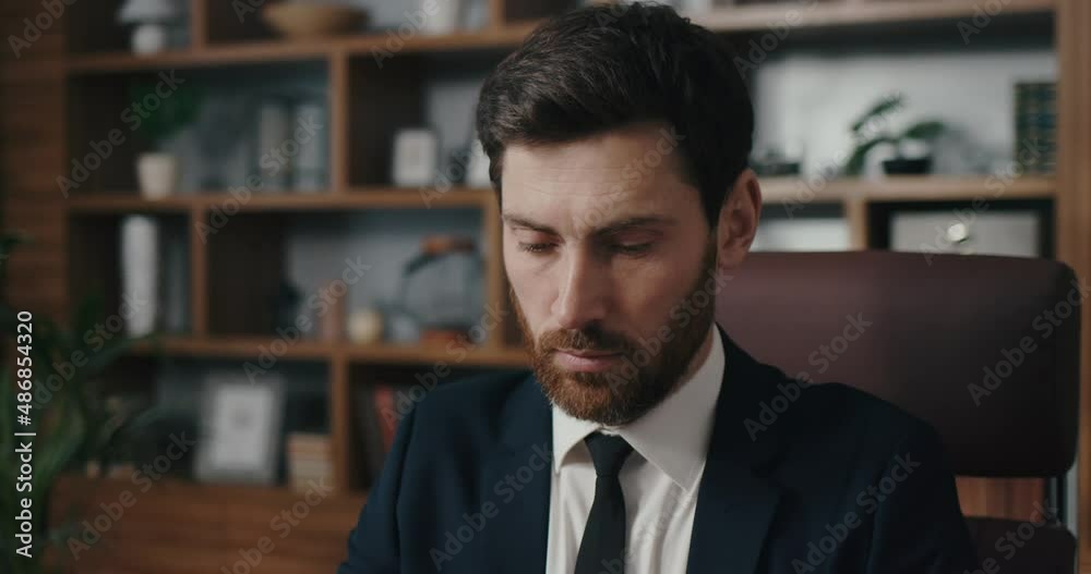 Manager opens laptop and starts working. Man portrait in cinematographic light. Handsome businessman is working in the office Manager opens laptop and starts working. Man portrait in cinematographic light. Handsome businessman is working in the office