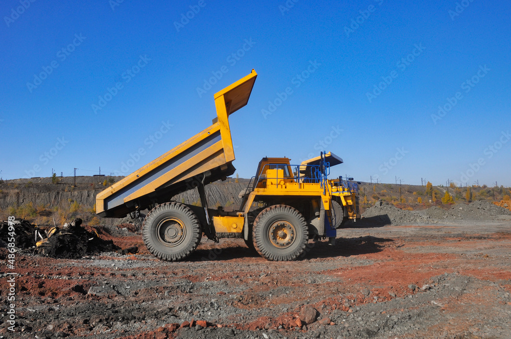 Dump truck unloads the overburden of an iron ore quarry Dump truck unloads the overburden of an iron ore quarry