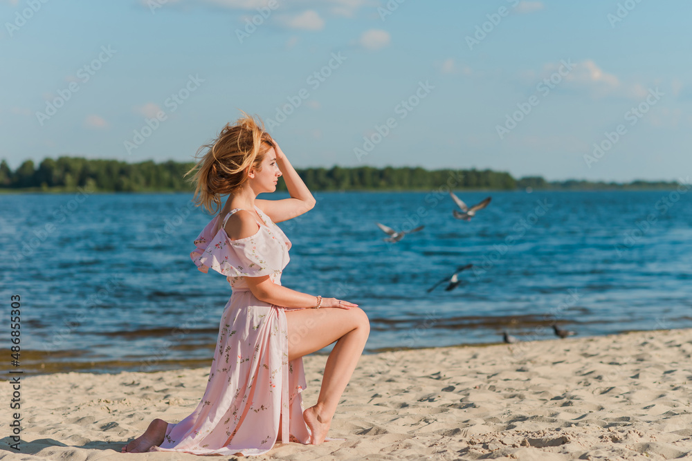 Woman in pink romantic soft long dress at beach, sunny warm day. Relax and freedom concept Woman in pink romantic soft long dress at beach, sunny warm day. Relax and freedom concept