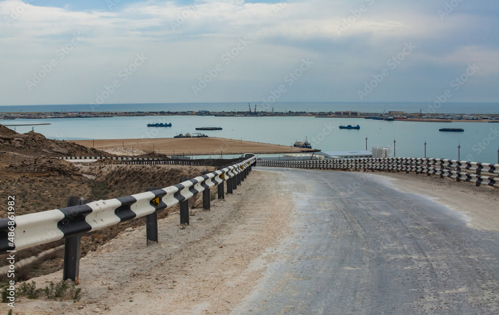 Road for oil trucks from tanker ship unloading terminal. Caspian sea, Kazakhstan. Bautino bay. Panorama view of the bay.