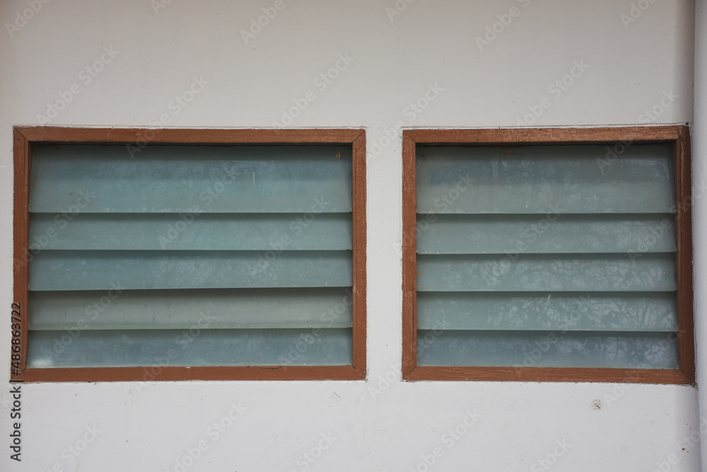 Ventilated louvered windows with wooden frames and opaque glass shutters. Ventilated louvered windows with wooden frames and opaque glass shutters.
