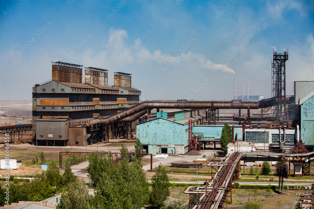 Main industrial building of metal alloy plant (smelter). Blue sky background. Main industrial building of metal alloy plant (smelter). Blue sky background.
